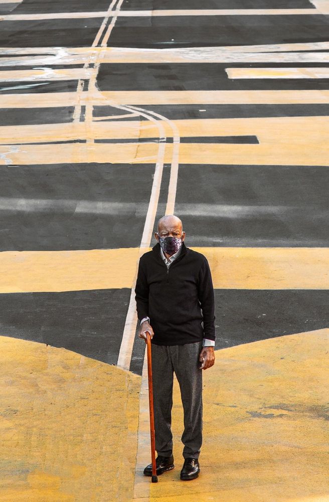 Congressman John Lewis standing in the midst of the Black Lives Matter mural on a road near the White House