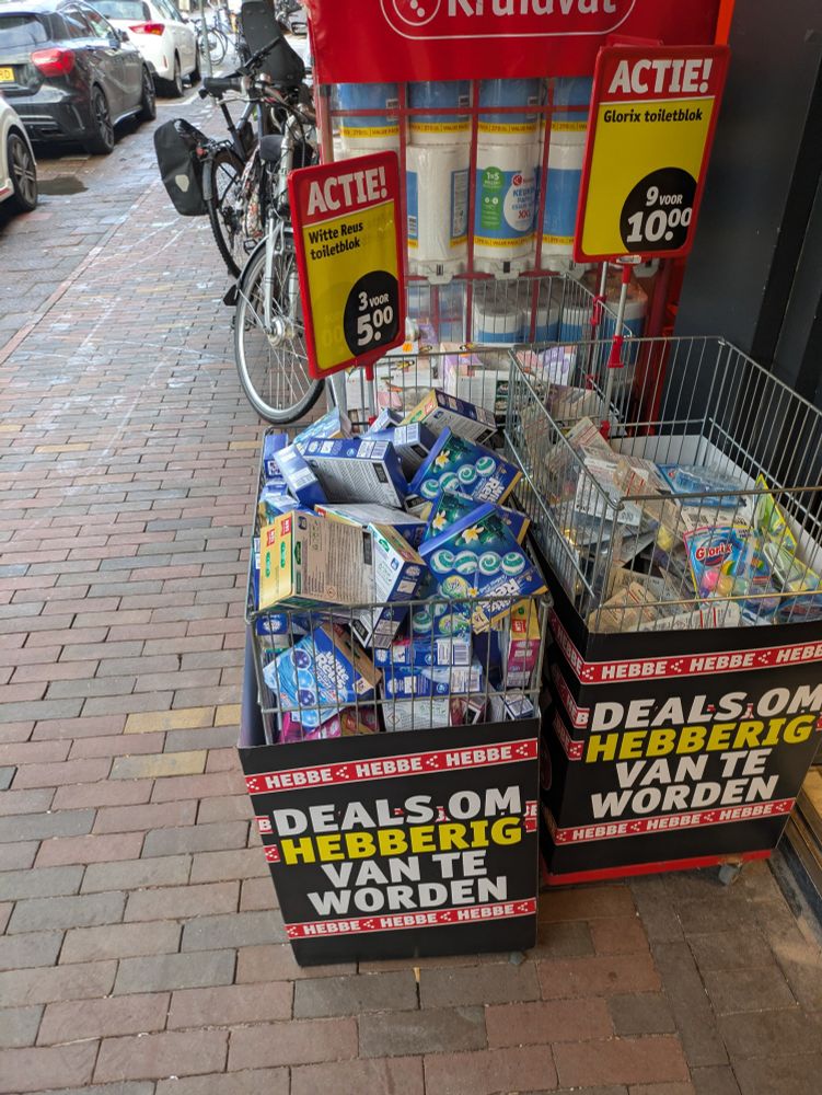 Een aanbieding van de kruidvat voor wc blokjes (3 voor 5 euro van Witte Reus en 9 voor 10 euro van glorix) in een doos waarop staat "deals om hebberig van te worden"