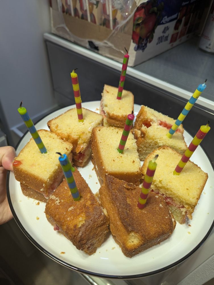 A cake cut like finger sandwiches with a jam filling and candles