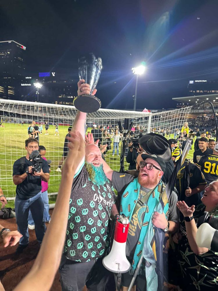 Fans lifting the USL Western Conference trophy. 