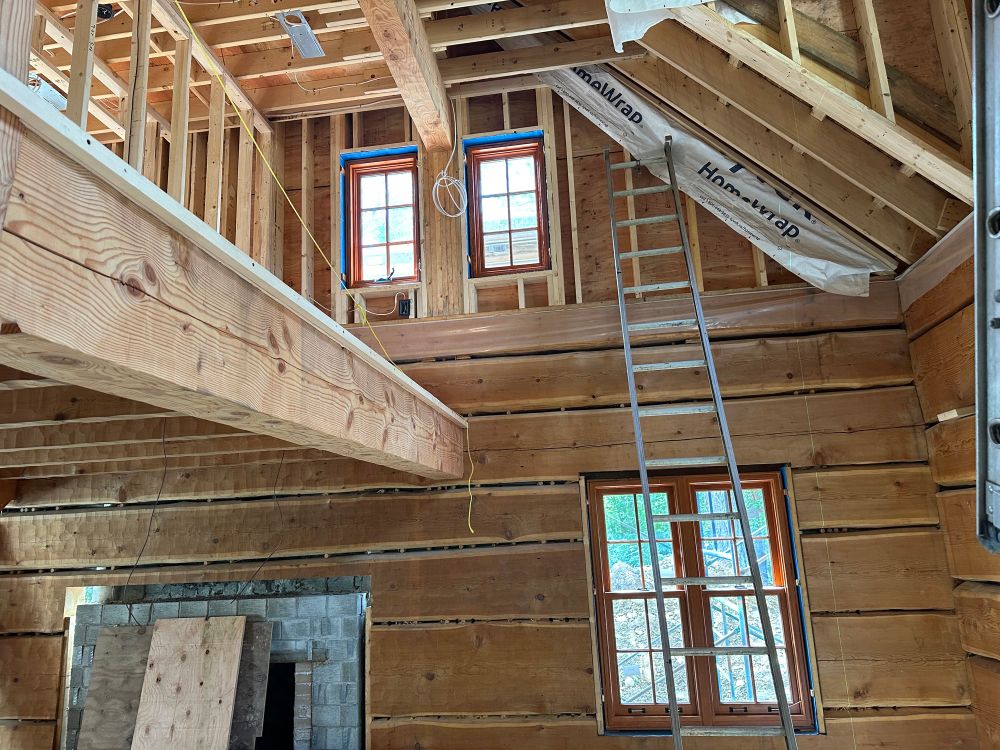 Single hung & casement windows installed in log and conventionally framed wall, awaiting interior chinking and trim work.