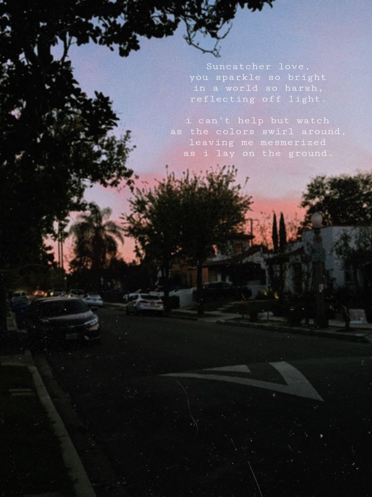 A picture of the sunset with pink and blue skies in a neighborhood. There is white text in the upper right corner that reads "suncatcher, love
you sparkle so bright
in a world so harsh,
reflecting off light.

i can't help but watch
as the colors swirl around,
leaving me mesmerized
as i lay on the ground."