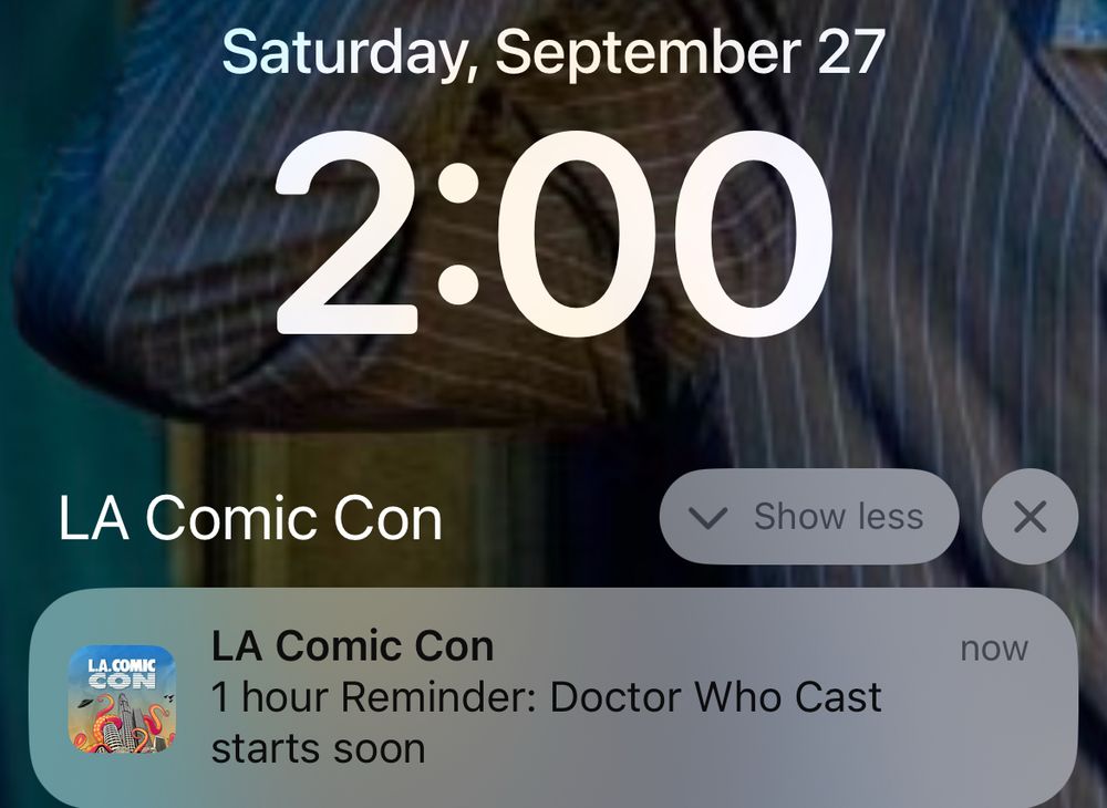 Screen capture of a phone Lock Screen that says today’s date and 2pm with a reminder from the LA Comic Con app that says: 1 hour Reminder: Doctor Who Cast starts soon