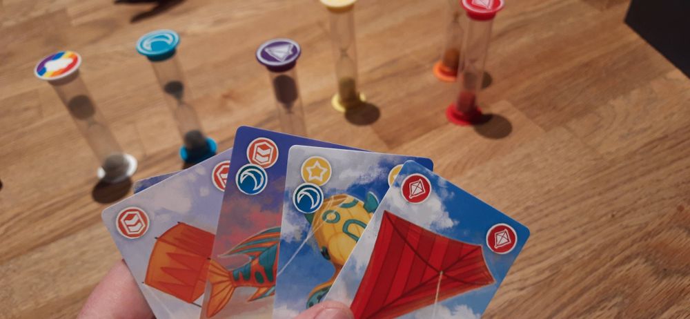 Bunte Drachenkarten und Sanduhren im Hintergrund