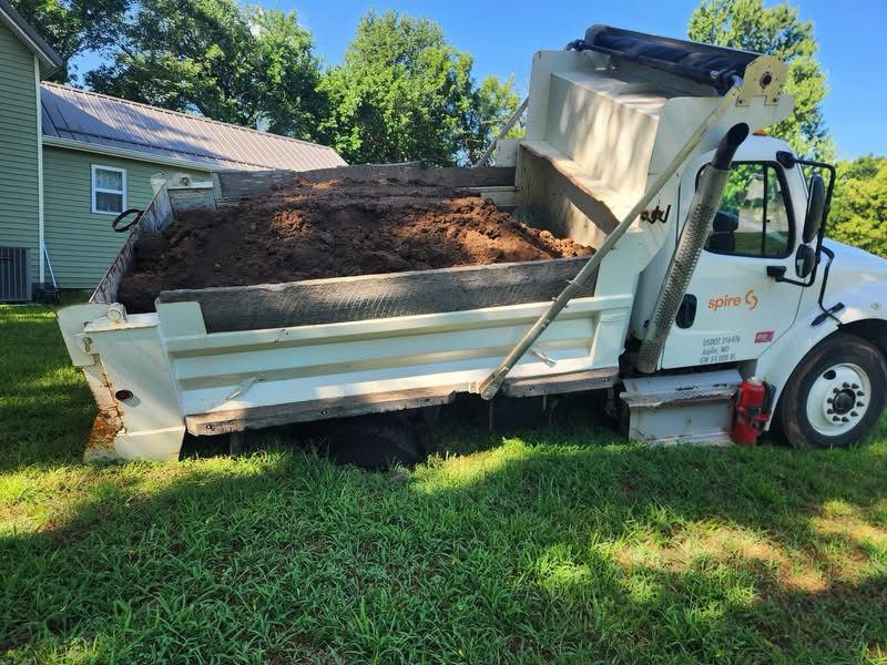 An image of a dump truck full of dirt that sunk into the septic tank in my friend’s yard.