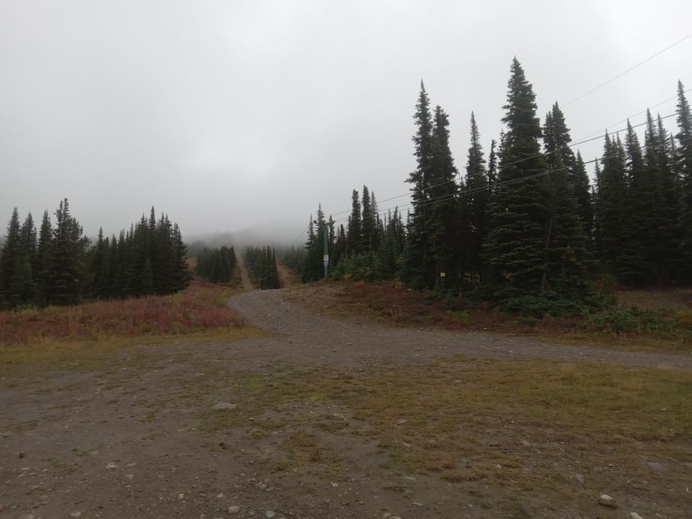 A ski lift on a mountain next to a gravel road