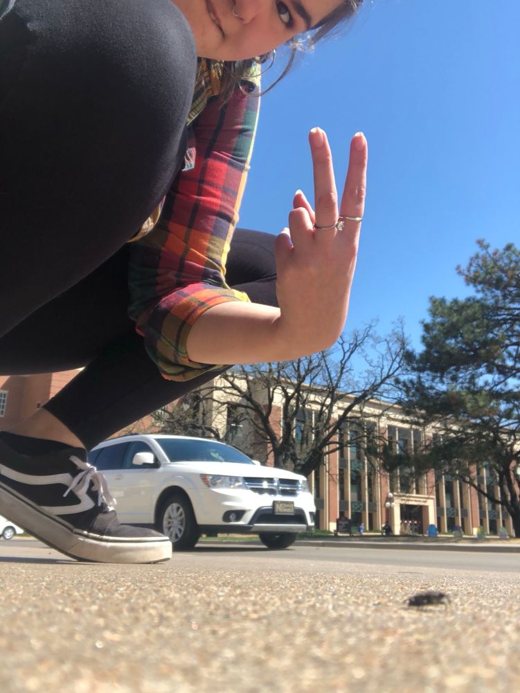 Bug girl throwing up a peace sign with a little weevil friend.