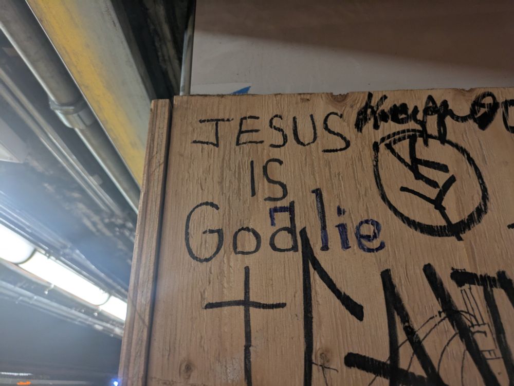 Graffiti ("Jesus is God") overwritten by other graffiti ("Jesus is a lie") overwritten by other graffiti. ("Jesus is Goalie")