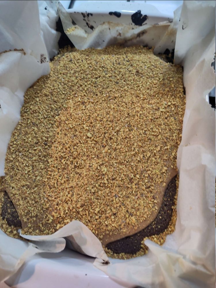 Chocolate browny cake with an caramel-pistachio topping in a baking tray