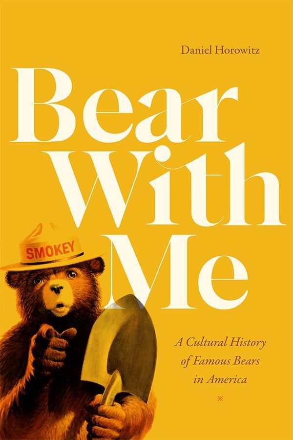 Cover of Bear With Me: A Cultural History of Famous Bears in America by Daniel Horowitz. Cover is yellow. The title is in large white text in the center. The author name is in small brown text in the upper right corner and the subtitle is in small brown text in the lower right. On the bottom left is an image of Smokey the Bear, holding a shovel, pointing directly at the viewer.