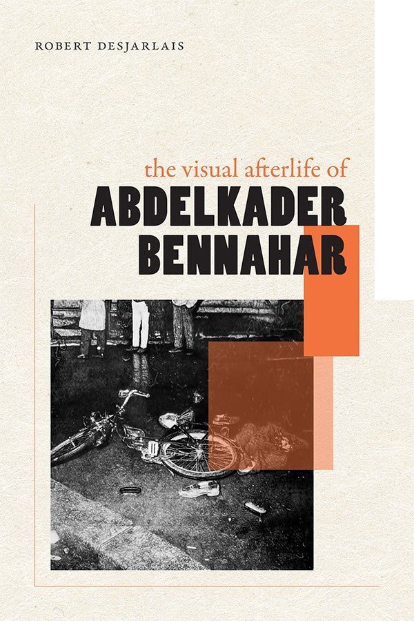 Cover of The Visual Afterlife of Abdelkader Bennahar by Desjarlais, Robert. The cover features a graphite drawing by Éric Manigaud, Elie Kagan #1. The hyperrealistic artwork depicts a damaged bicycle lying on its side in a wet street, surrounded by scattered shoes and debris. A crumpled bundle of clothing lies nearby. In the background, four people stand along a wall, partially reflected in a large puddle. The scene is dimly lit and grainy.