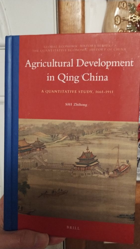 The OP holding the book Agricultural Development in Qing China: A Quantitative Study, 1661–1911 by Shi Zhihong