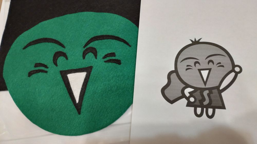 悪天候用のすだちくんうちわの表が完成したところ。裏面は右のイラストにある標準型すだちくんと呼ばれるタイプをシルエットにしたものにする予定。この方法は、すだちくんTシャツの袖にも採用されている