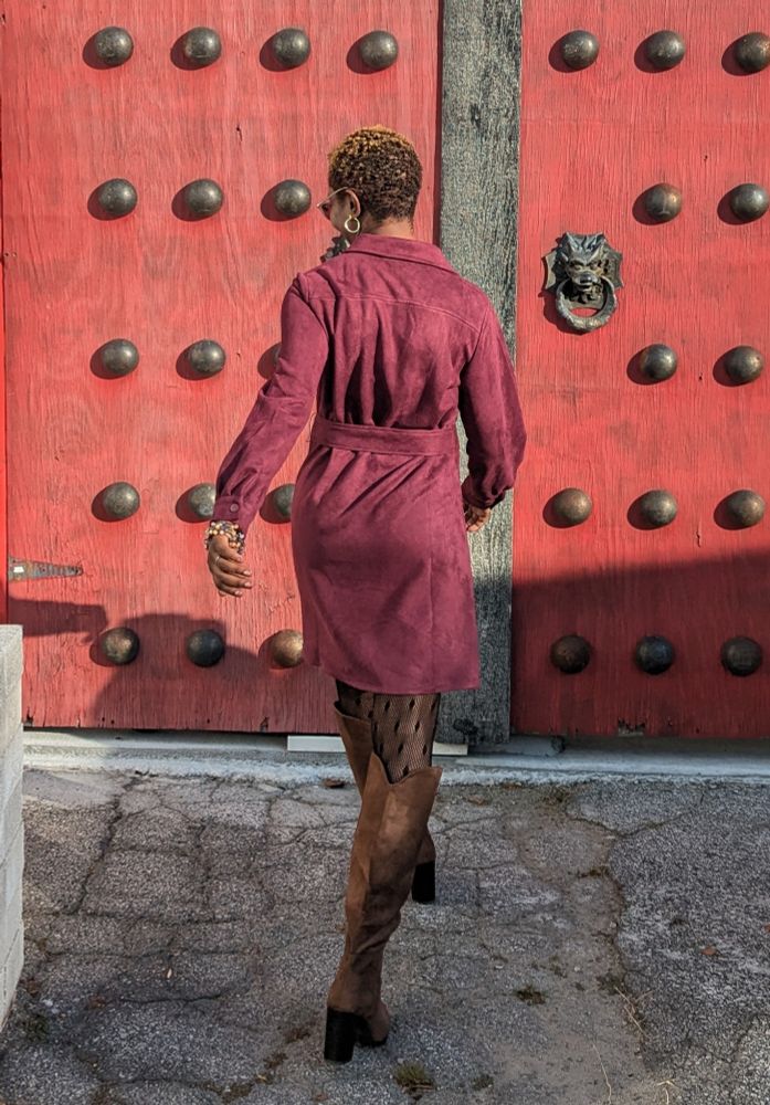 Me walking wearing a burgundy dress, black polkadot hosiery, and brown knee high boots