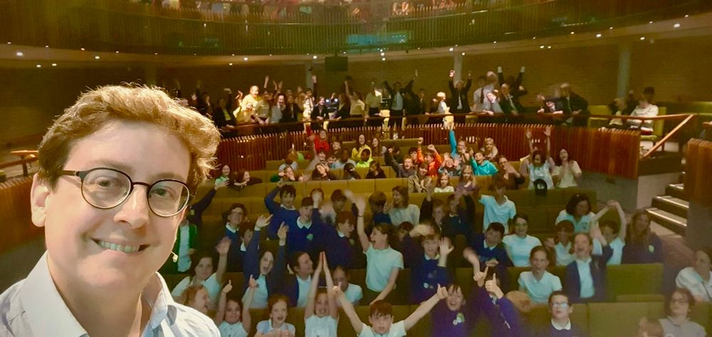 A selfie with an audience of cheering kids 
