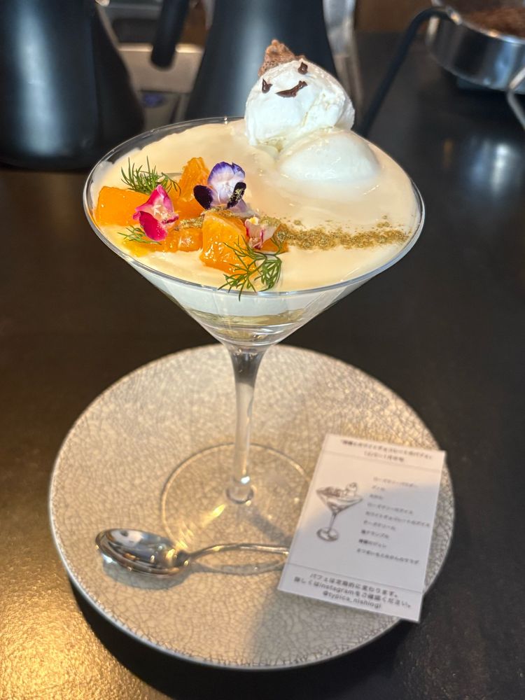 西荻窪ティピカの『柑橘とホワイトチョコレートのパフェ』
カクテルグラス型のパフェ、チーズクリームの上にフルーツや花、ローズマリーアイスの雪だるまが乗っている
パフェの最下層はさつまいもとみかんのサラダ
本当にサラダなので、ベビーリーフも入ってる
でも一応デザート