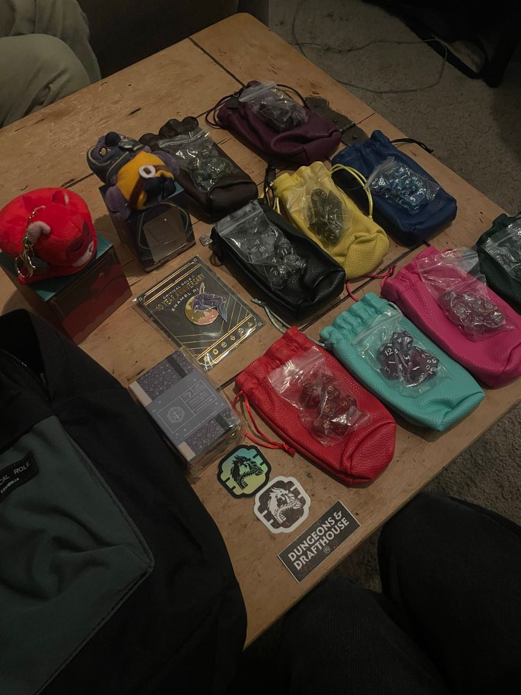 My loot from the backpack I won by doing a Jester impression, featuring all Mighty Nein dice sets (sans Essek, but that’s okay—I already have him!!), a Frumpkin and Kiri plush, the 10th anniversary enamel pin, a CR sticky note 3-pack, and 3 Dungeons & Drafthouse stickers.