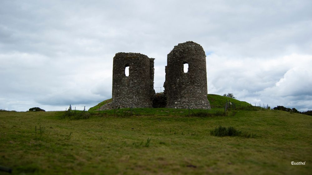 Two shattered towers loom atop a hill under a leaden sky in County Tyrone