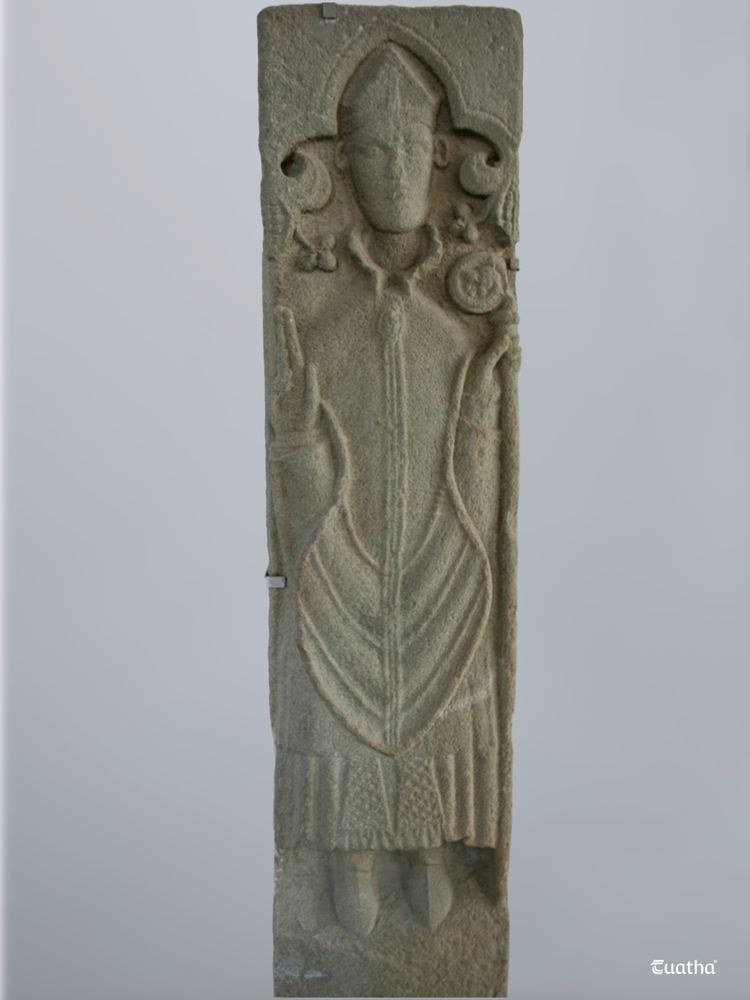 A medieval stone effigy of a man in the garb of a bishop
