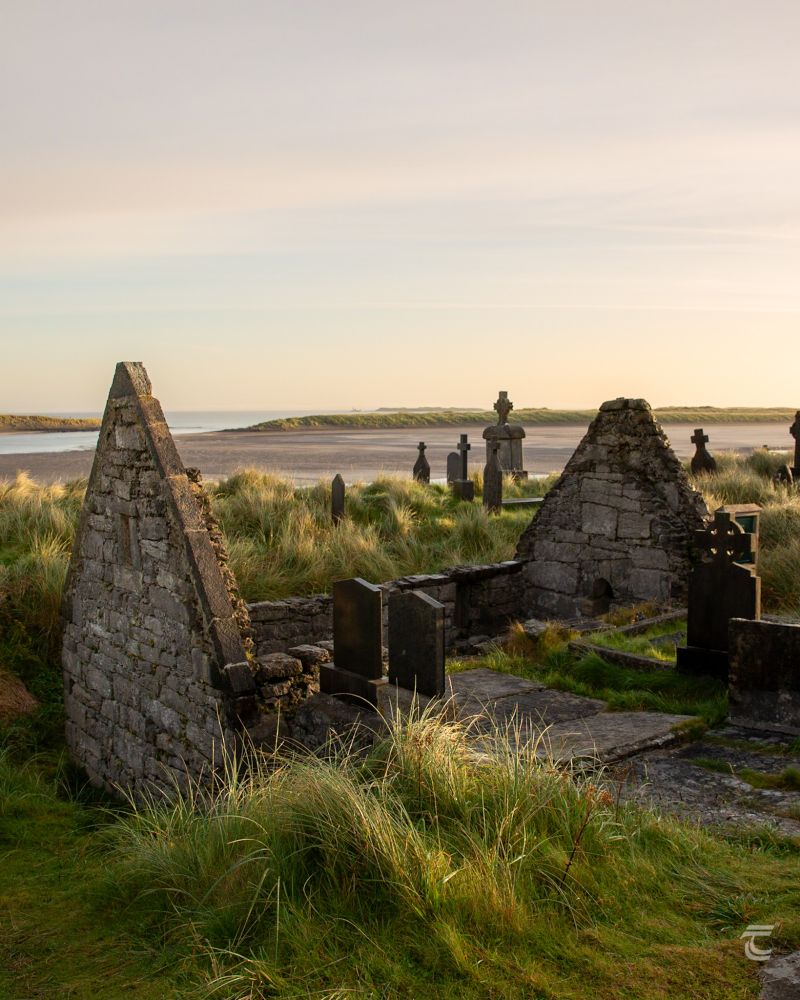 The gables of a ruined medieval church soar from swallowing sand