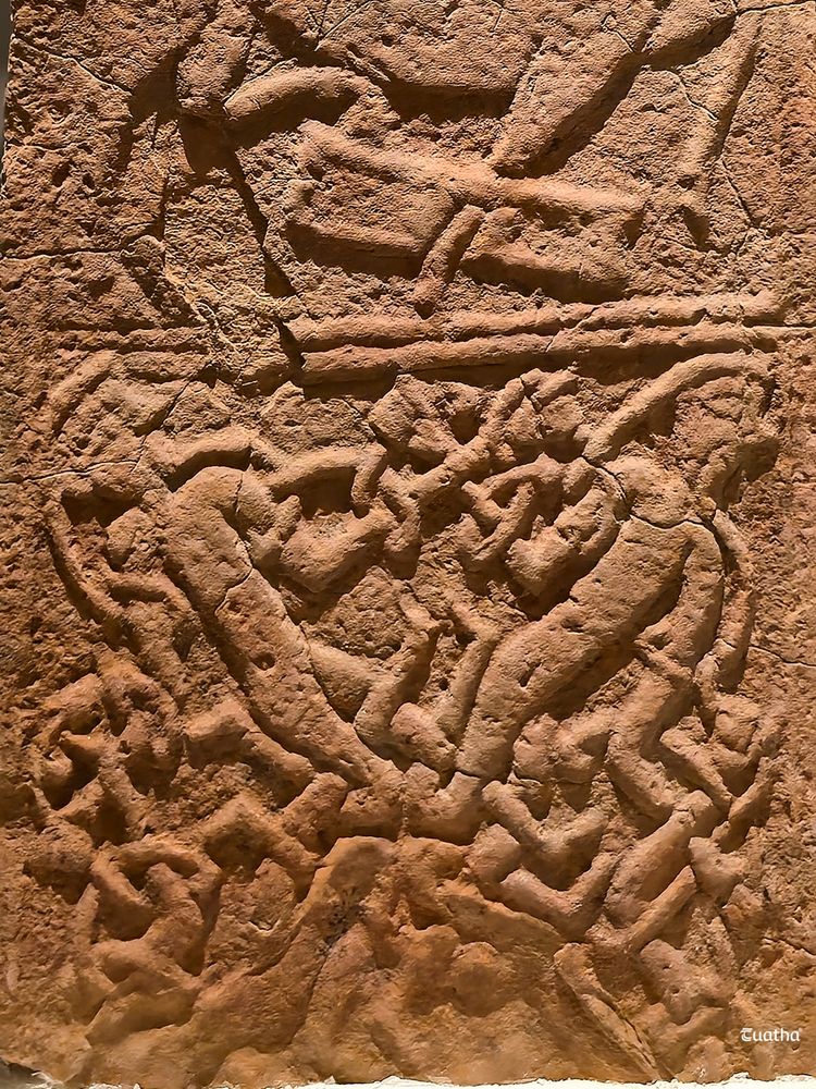 Two bearded figures entangled in interlace ornament