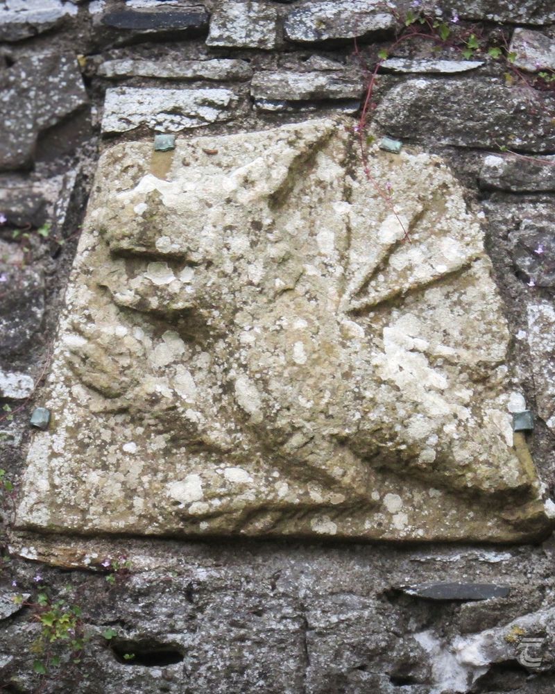 an architectural fragment on a stone wall depicting a dragon