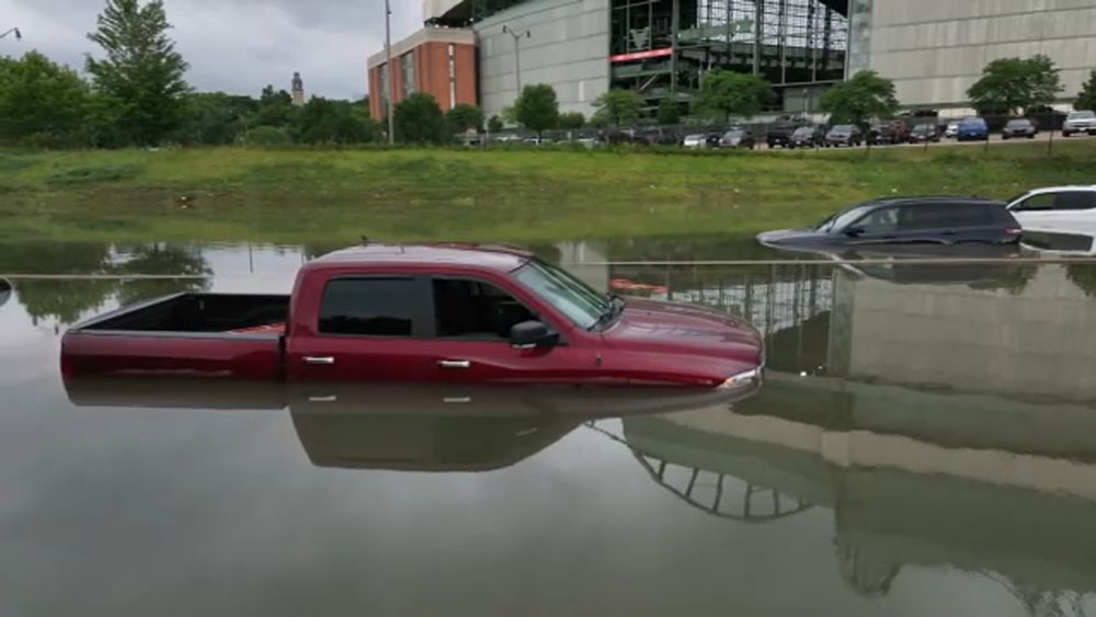 cars and trucks stuck in flood waters at Brewers Ballpark with water at the door handles