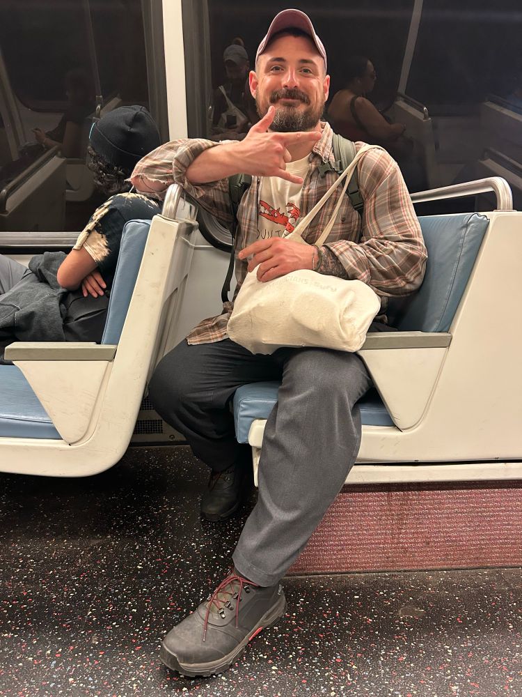 Man throwing a love sign on a train 