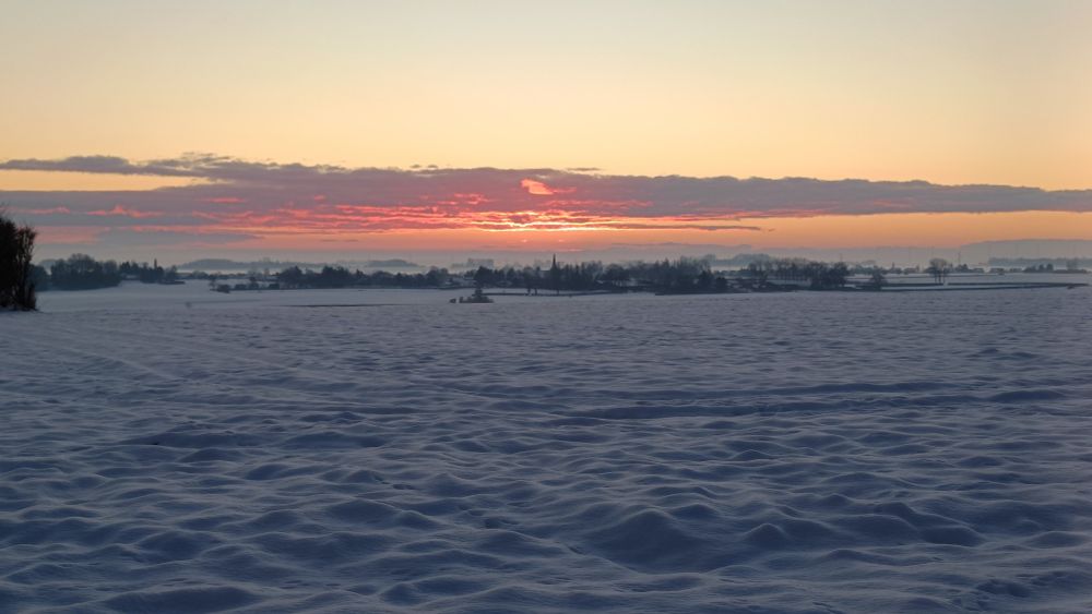 Ciel de fin de journée soleil couchant sur campagne enneigée