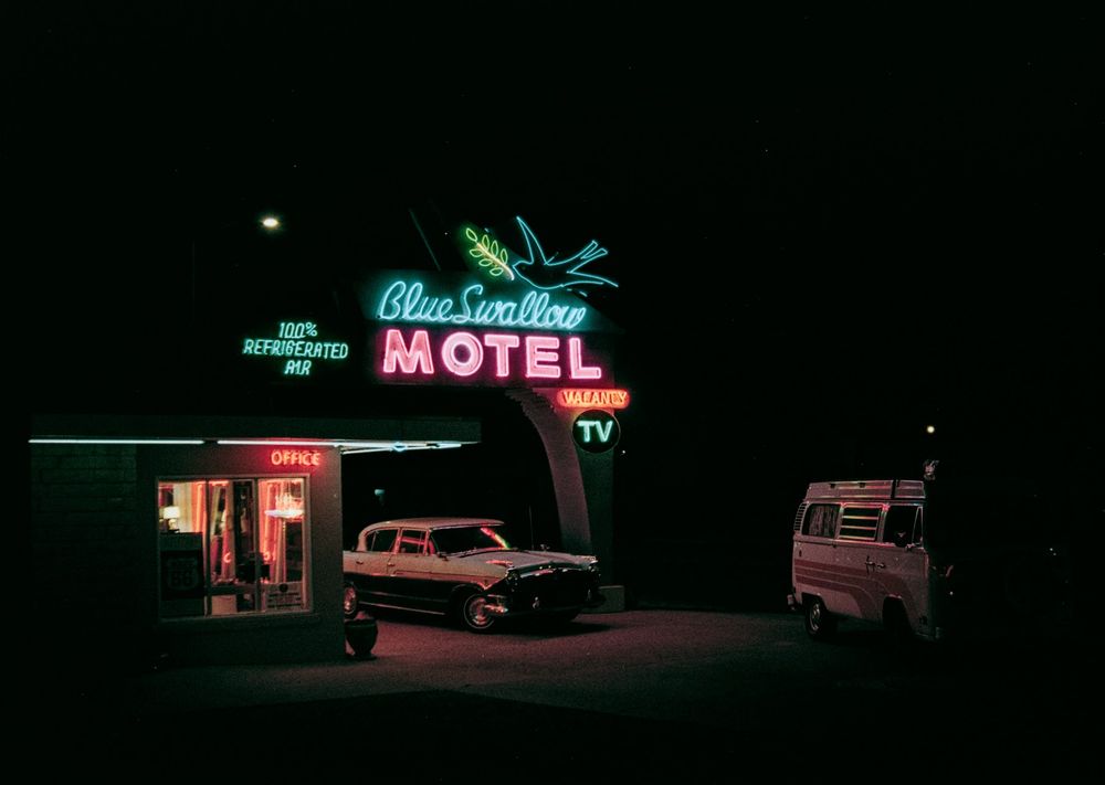 Blue Swallow Inn at night lit up by its neon signs.