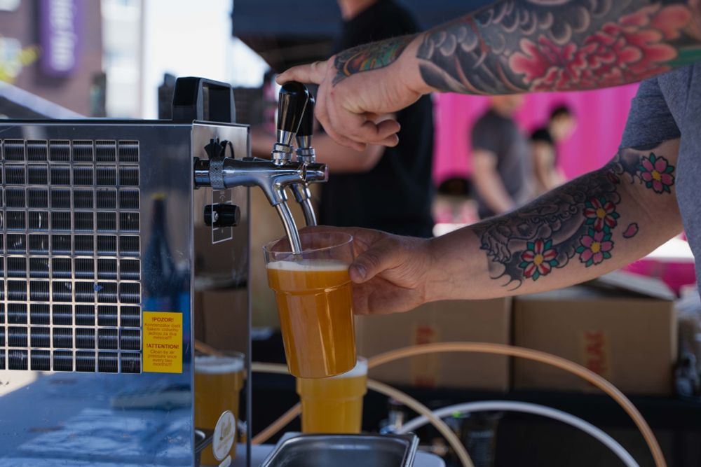 Photo of a pint of craft beer being poured at a beer festival in Future Yard's outside space.