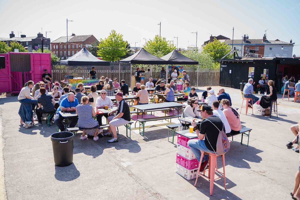 Another photo of groups of people sat in the sun enjoying beers at a beer festival in Future Yard's outside space.