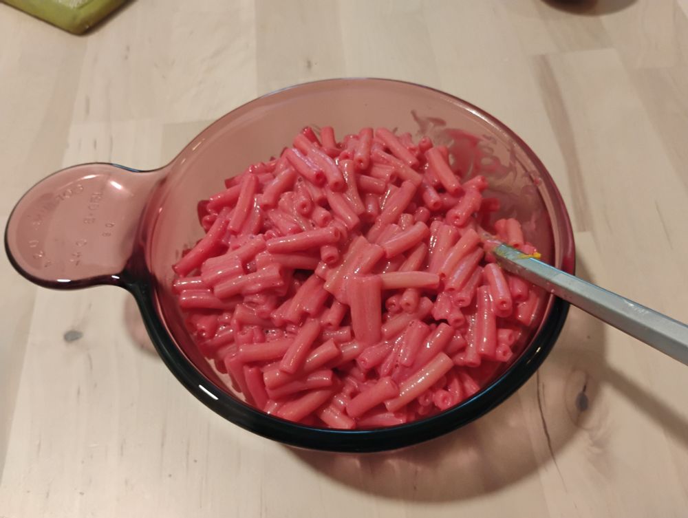 pink mac and cheese in a clear purple corningware bowl. pray for me.