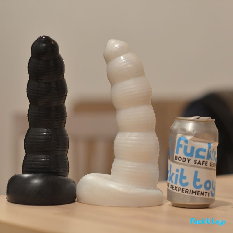 Two large bumpy dildos next to a soda can about their width and half their height. They're shimmery black and white, and shaped like a stack of six orbs with ringed grooves around their midsecions. They decrease in size as they go up from the base, with the third from the bottom being smaller than the one above, so it's thicker at the top and bottom. It's like a drunk snowman, really. It's also a joke on a certain tire mascot, if you hadn't picked that up yet. Proper attire, like tires and also 3 star restaurants. I'm not sorry.