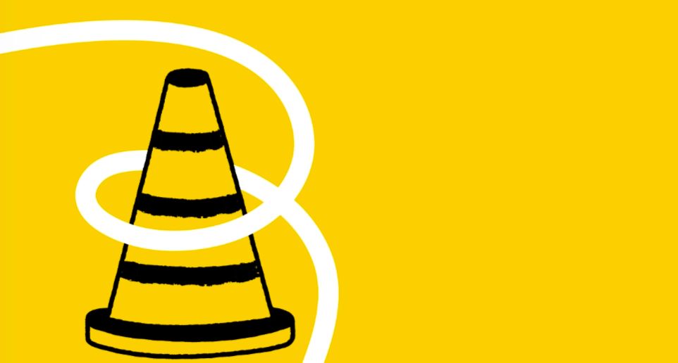 Cône de travaux sur fond jaune.