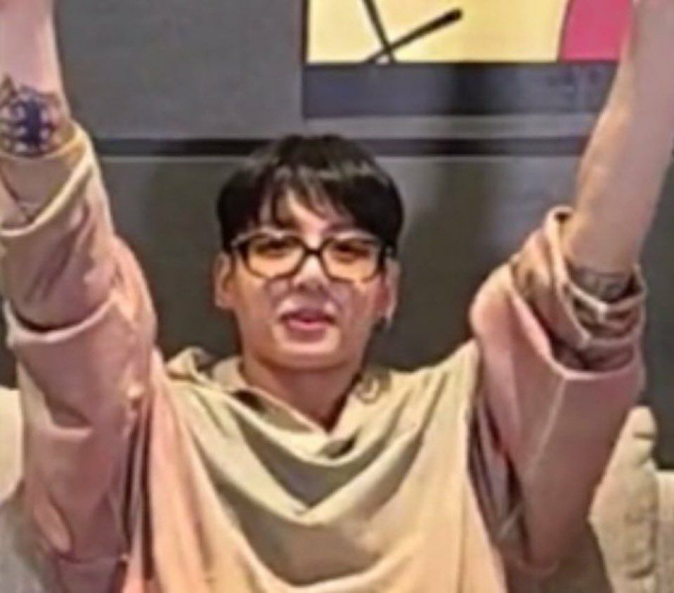 Screengrab of Jungkook from BTS ot7 Live July 1, 2025. Arms are raised over his head revealing tattoos on both arms near his elbow.