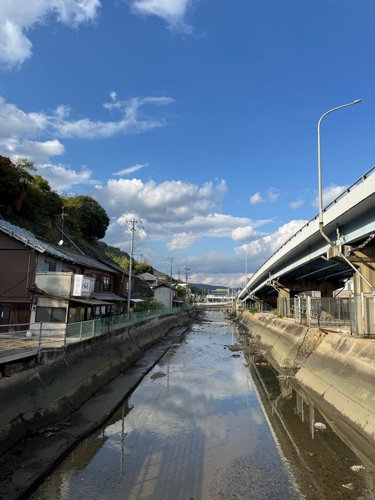 A view up a narrow waterway with traditional Japanese houses on the bank