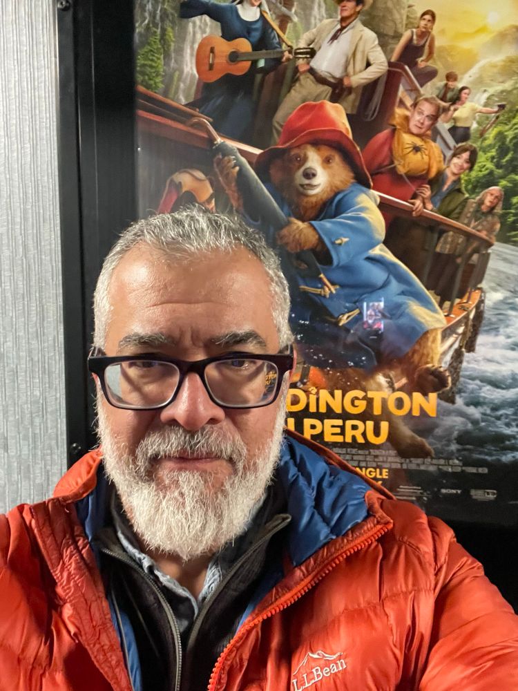 Me standing in front of a movie poster for paddington in Peru 