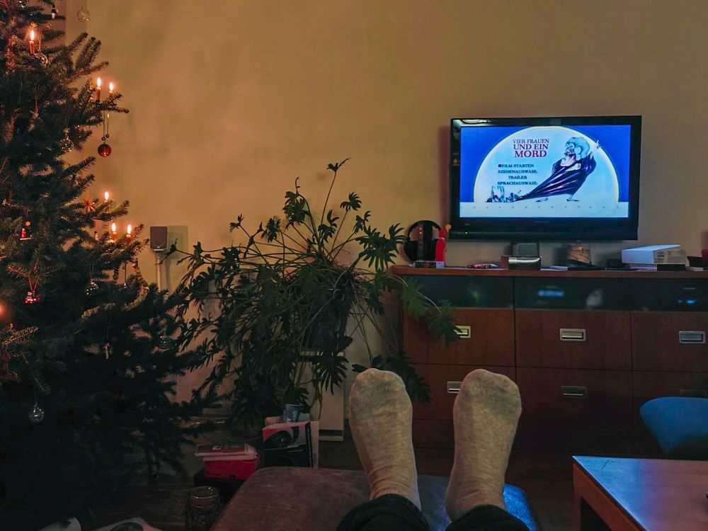 Photo von einem Fernseher und einem Weihnachtsbaum. TV zeigt Bild aus Vier Frauen und ein Mord