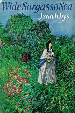 Classic cover of Wide Sargasso Sea with Jean Rhys, picturing a white woman with black hair dressed in a nineteenth century shawl. She is surrounded by tropical plants.