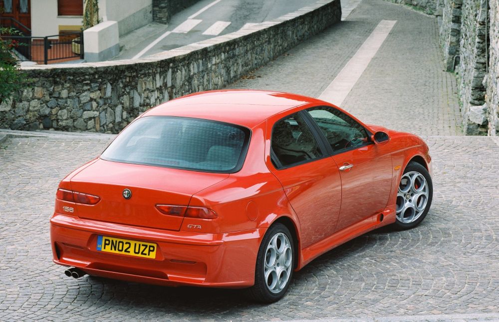 A red Alfa Romeo 156, rear side view.
