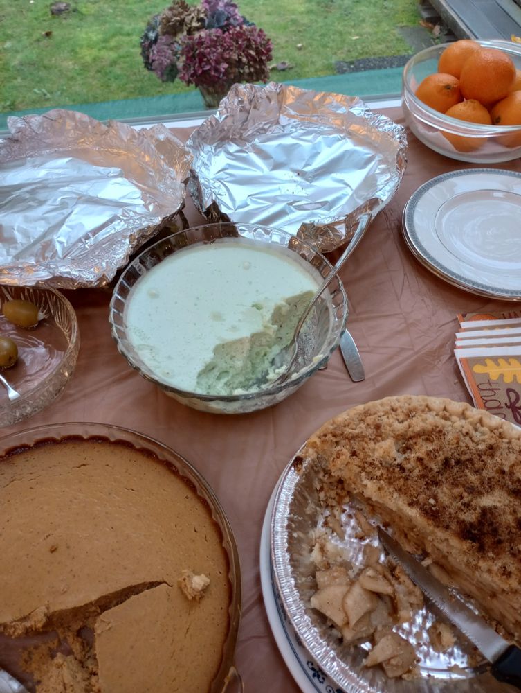 Green lime jello salad with crust-free pumpkin pie and an apple pie on a table.