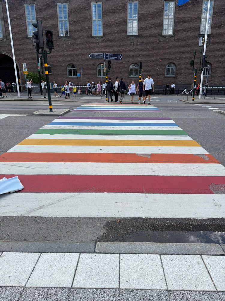 a pedestrian crossing painted with a rainbow at stockholm city hall