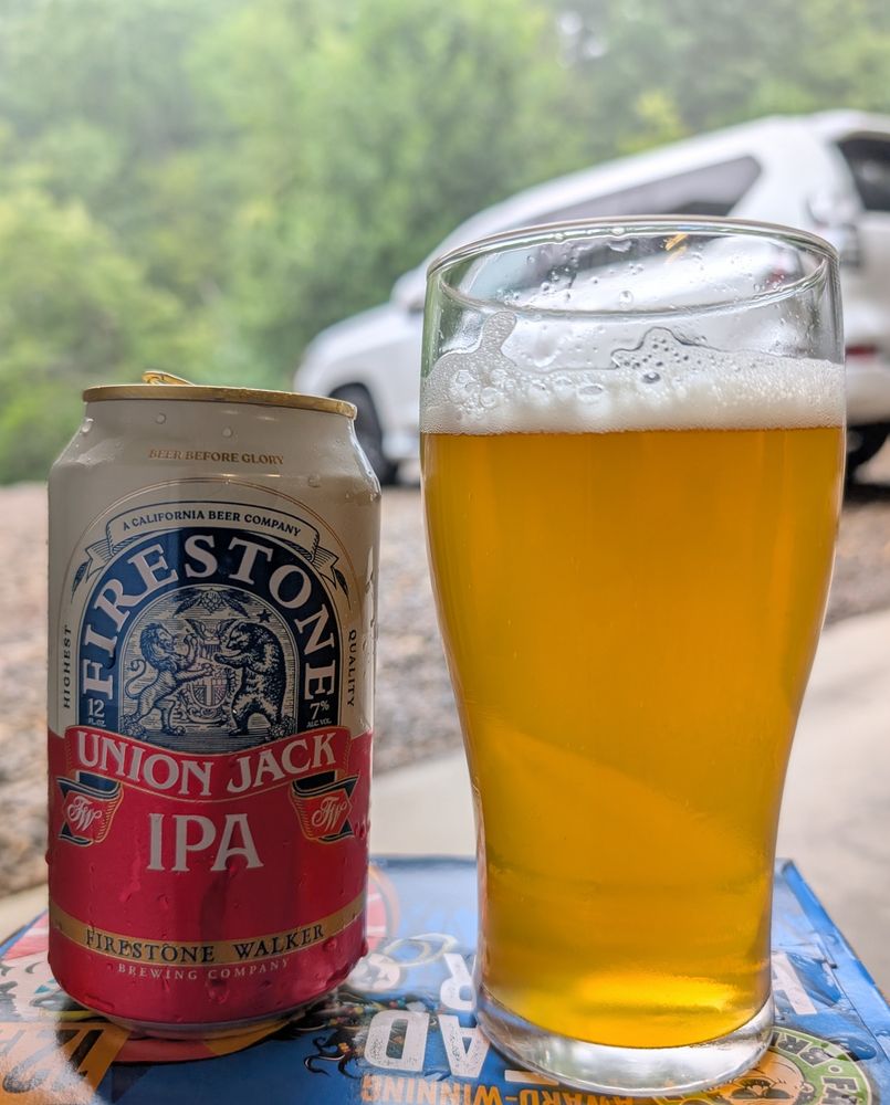 Firestone Union Jack IPA poured into a glass. It's pouring rain in the background. We don't give a fuck as it was still a great day and we're on vacation.