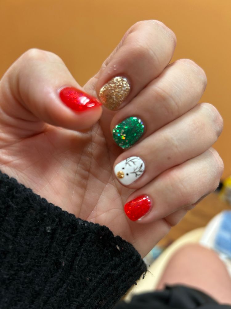 fingernails painted in red, green, and gold with a little reindeer.