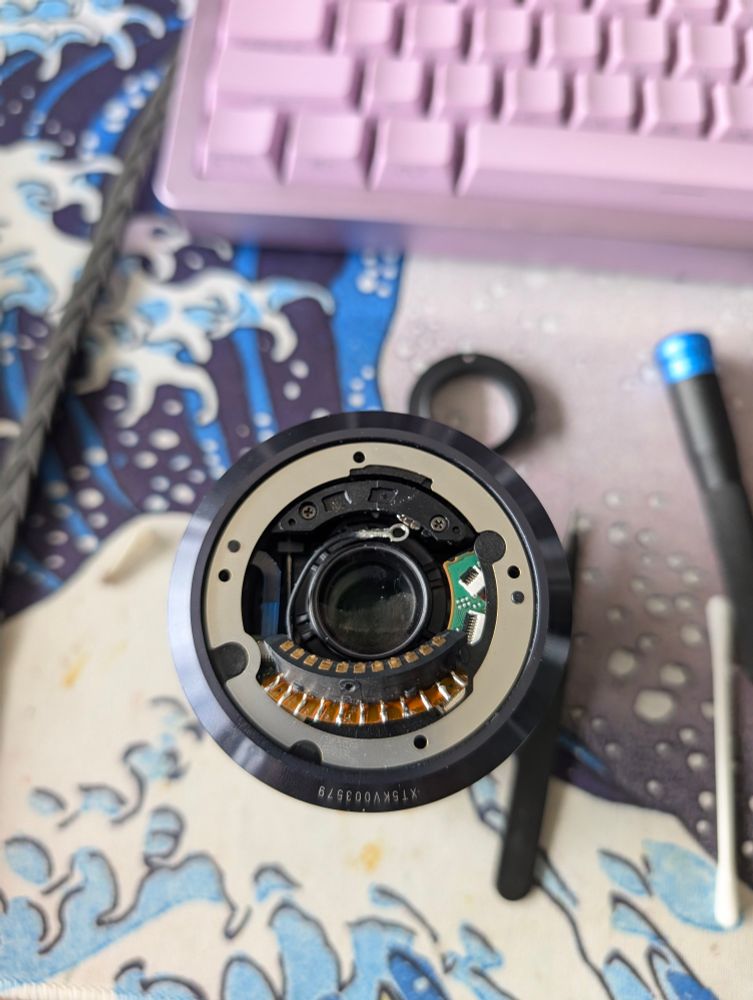 Reassembling the lens after plugging the electronic contact bar back into its socket on the lens logic board 
