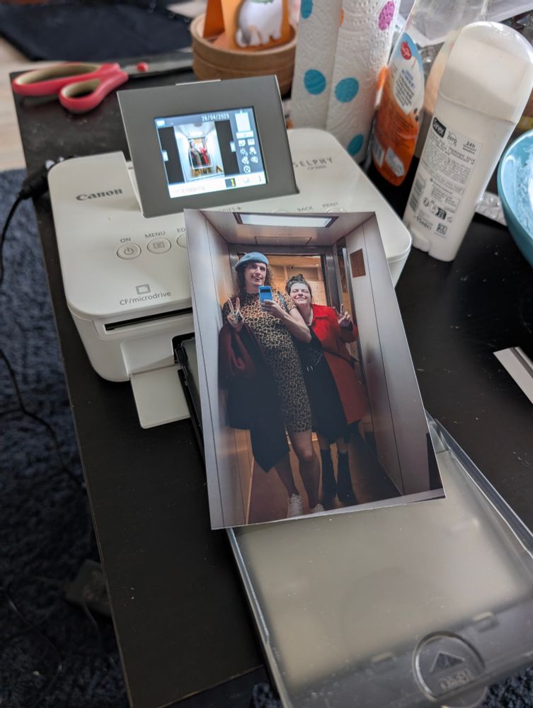 Photo of a small Canon photo printer with a print on a table