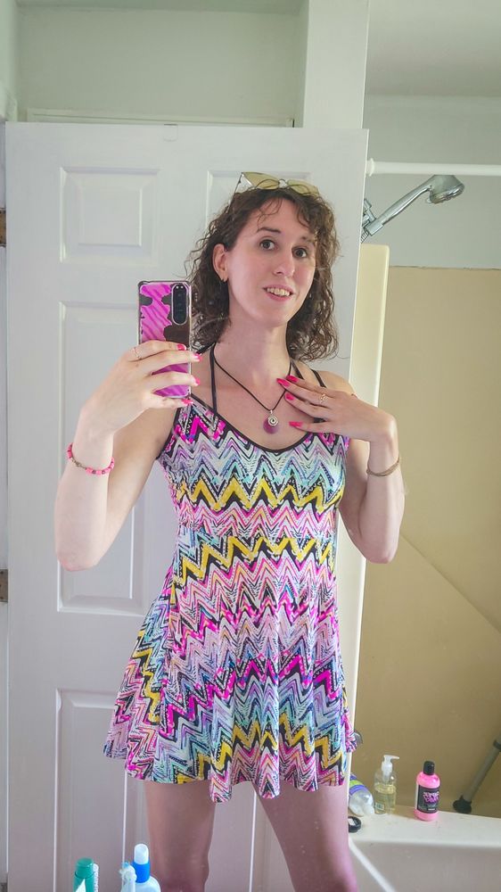 selfie in a short skater dress with neon multicolor zigzags across it