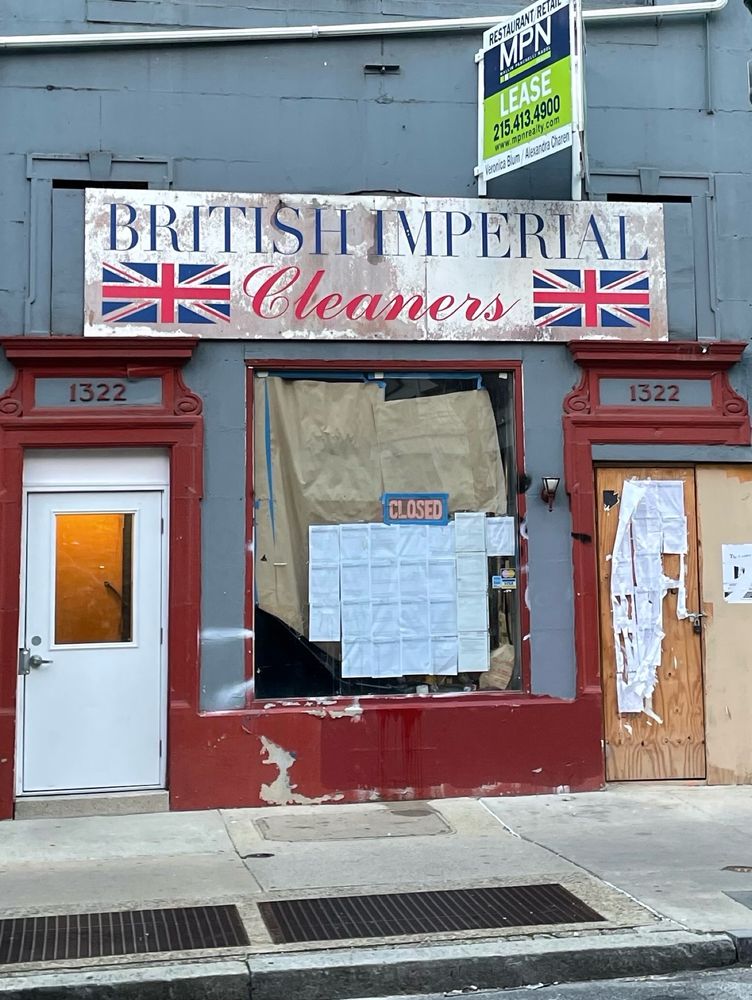 A picture of British imperial cleaners in Philadelphia, Pennsylvania. The store is closed, and there are many notices pasted to the window and doors.