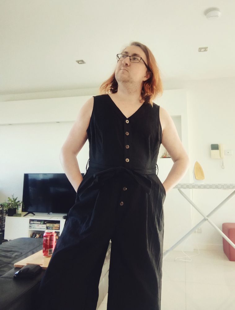 Jasmine in 2021 (no i don't have photos from 2022 woops) in a jumpsuit, looking wistfully into the distance because this outfit would pop off if she had tits to fill out the top half.  